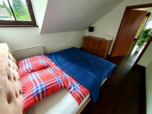 ZabierzówSuite Loft的一间卧室配有一张带蓝色棉被的床