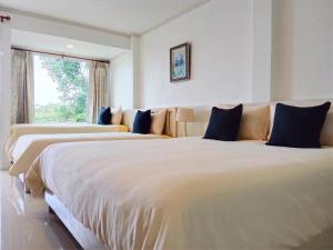 格兰岛Koh Larn Riviera的白色客房的两张床,设有窗户