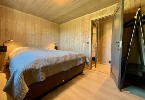 莱克内斯Haukland Beach View - Superior cabin的一间卧室设有一张床,门通往走廊