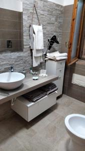 圣尼科拉阿尔切拉Villetta Clorinda的浴室配有盥洗盆、卫生间和盥洗盆。