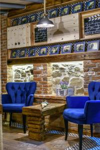 特里卡拉Traditional Guesthouse的一间设有蓝色椅子和石墙的房间