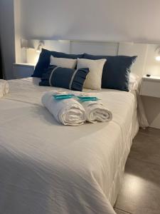 罗萨里奥Suites Quality 2 - Rosario的一张白色的床,上面有两条毛巾