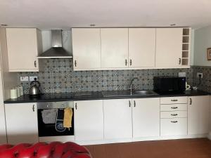 米德尔斯伯勒Charming 1-Bed Studio in Middlesbrough的厨房配有白色橱柜和水槽