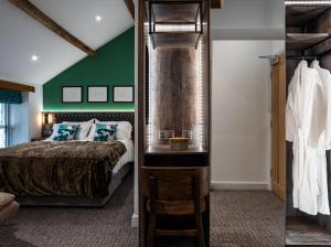 Highpeak JunctionThe Swan Inn的一间卧室设有一张床和绿色的墙壁