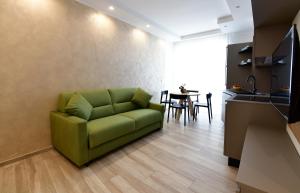 滨海波利尼亚诺Vilu Suite Centro的客厅配有一张绿色沙发,设有一张桌子