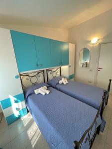 帕拉迪索海岸Veranda sul Paradiso的一间卧室配有2张蓝色的床和蓝色的橱柜
