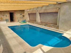 Vega de Santa MaríaCasa Rural Baños del Rey con piscina climatizada的一座石墙房子里的一个大型游泳池