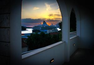 杜布罗夫尼克Apartments Tayra的日落时分的游船景窗户