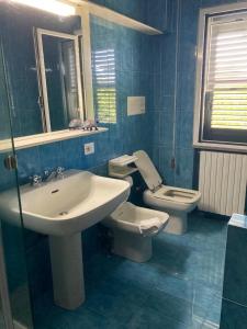 蓬塔阿拉Appartamenti Podere 270的蓝色的浴室设有水槽和卫生间
