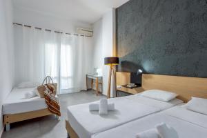 赫索尼索斯Azure Mare Hotel的酒店客房,配有两张床和椅子