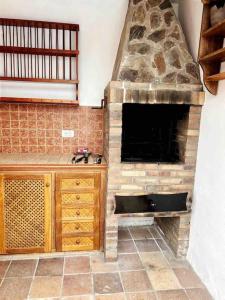 拉克鲁斯lujosa villa con piscina privada的一间厨房,在房间内配有石制壁炉