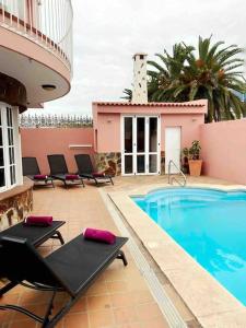 拉克鲁斯lujosa villa con piscina privada的一座带游泳池和椅子的度假村,毗邻一座建筑