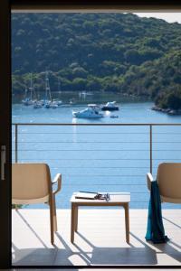 塞沃塔Sivota Deamaris Luxury Boutique Hotel的享有水景和船景的阳台
