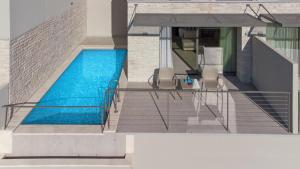塞沃塔Sivota Deamaris Luxury Boutique Hotel的一座带两把椅子的房子内的游泳池