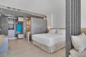 塞沃塔Sivota Deamaris Luxury Boutique Hotel的卧室配有一张白色的大床和一张沙发。