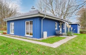 阿尔特费尔Ferienhaus 28 Altefhr的院子里带长凳的蓝色房子