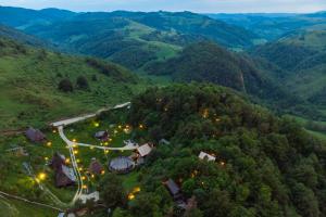 Sub PiatraRaven's Nest - The Hidden Village, Transylvania - Romania的享有山脉村庄的空中景致