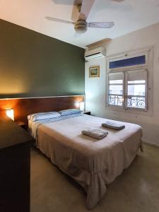 布宜诺斯艾利斯卡洛斯葛戴尔旅馆的一间卧室配有一张床,上面有两条毛巾