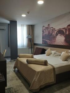 莫斯塔尔赫塞哥维纳汽车旅馆的一间卧室设有两张床,墙上挂着一幅画