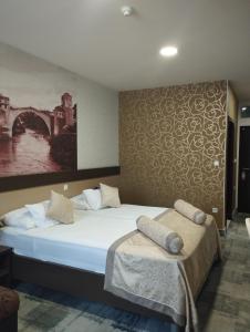 莫斯塔尔赫塞哥维纳汽车旅馆的卧室配有一张床,墙上挂有绘画作品