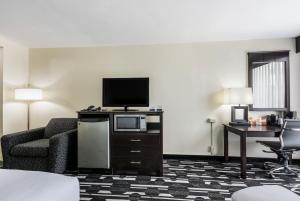 俄克拉何马城Days Inn by Wyndham Oklahoma City Bricktown的酒店客房配有电视、沙发和椅子。