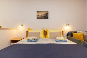 木洛希尼Villa Teresa的一间卧室配有一张大床,提供黄色和蓝色的枕头