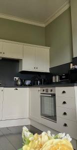 科克茅斯Dovenby Apartment- great base for exploring Lake District的厨房配有白色橱柜和炉灶烤箱。