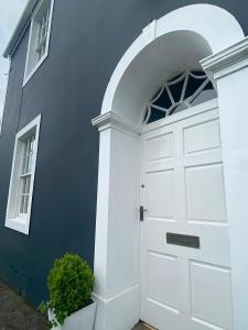 科克茅斯Dovenby Apartment- great base for exploring Lake District的蓝色建筑上一扇带窗户的白色门