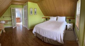阿尔马Alma Shore Lane Suites & Cottages的卧室设有白色的床和绿色的墙壁