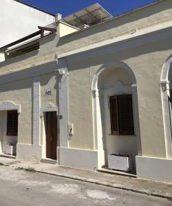 斯佩基亚Lu Caleddhu的白色的建筑,设有两扇窗户和一扇门
