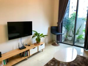 胡志明市Lagom service apartment Ho chi minh city - airport的客厅设有壁挂式平面电视。