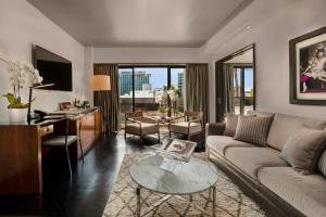 洛杉矶60比佛利山酒店的客厅配有沙发和桌子