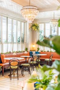 洛杉矶60比佛利山酒店的餐厅设有桌椅和窗户。