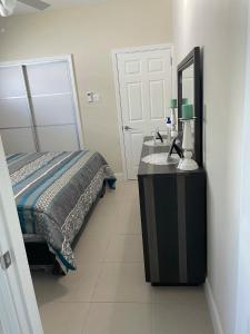 卢西Aquamarine Resort-style Vacations的一间卧室配有一张床,梳妆台上配有镜子
