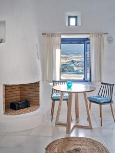 MárpissaLeticia Villa with pool with amazing sea views, Paros的带壁炉的客房内的一张桌子和两把椅子
