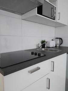 恩斯赫德Annalisa Guest House Centrum的厨房配有白色橱柜和炉灶烤箱。