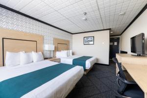 怀特霍斯Sternwheeler Hotel and Conference Centre的酒店客房设有两张床和一台平面电视。