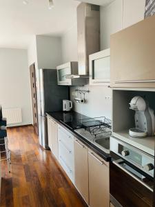 鲁容贝罗克Apartment Mira的厨房配有白色橱柜和黑色台面