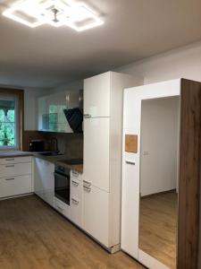 圣卡尼兹Bauernhof Podorn的一间厨房,配有白色的橱柜和一扇开放式门