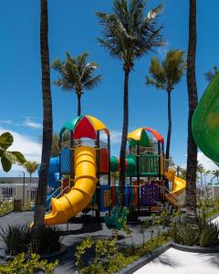 萨利诺波利斯Salinas Premium Resort的一个带滑梯和棕榈树的游乐场