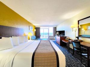 弗吉尼亚海滩Ocean Resort的酒店客房设有一张大床和一张书桌。