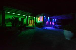 基萨莫斯Villa Olive Tree with Private Pool的夜晚亮起的有绿色和紫色灯光的房子