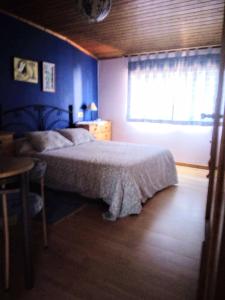 格罗韦Casa, apartment dúplex independiente的一间卧室配有一张床、一张桌子和一个窗户。