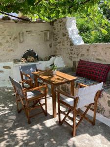 干尼亚Sergios Village House的一张木桌、椅子和一张带壁炉的沙发