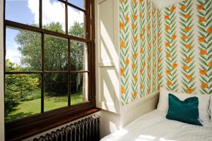 欧克希尔Topside House - Beautiful 7 bedroom house with hottub wifi and parking near Bath Wells Frome的一间卧室设有一张床和一个窗口