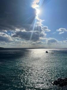 梅塔Residenza Mare di Sotto Sorrento的阳光在海洋上闪烁,天空和云朵