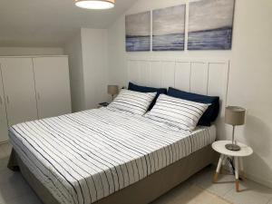 雷卡纳蒂港La Casa BluMare的一间卧室配有一张带蓝色和白色棉被的床