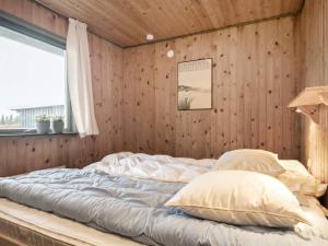 博恩瑟Holiday home Bogense XXXIII的木墙客房的一张床位