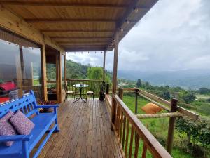 圣弗朗西斯科Refugio Naturaleza en Armonia的木甲板上设有蓝色长椅的门廊