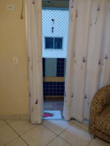 圣维森特岛Praia, sol e lazer的带窗帘的门和瓷砖地板的客房